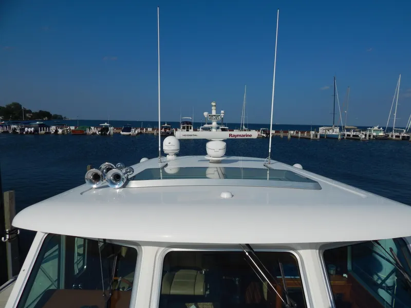 Slide: The Image of 2010 Sabre 40 Sedan yacht with Raymarine equipment, docked at a marina under clear blue skies. - 5