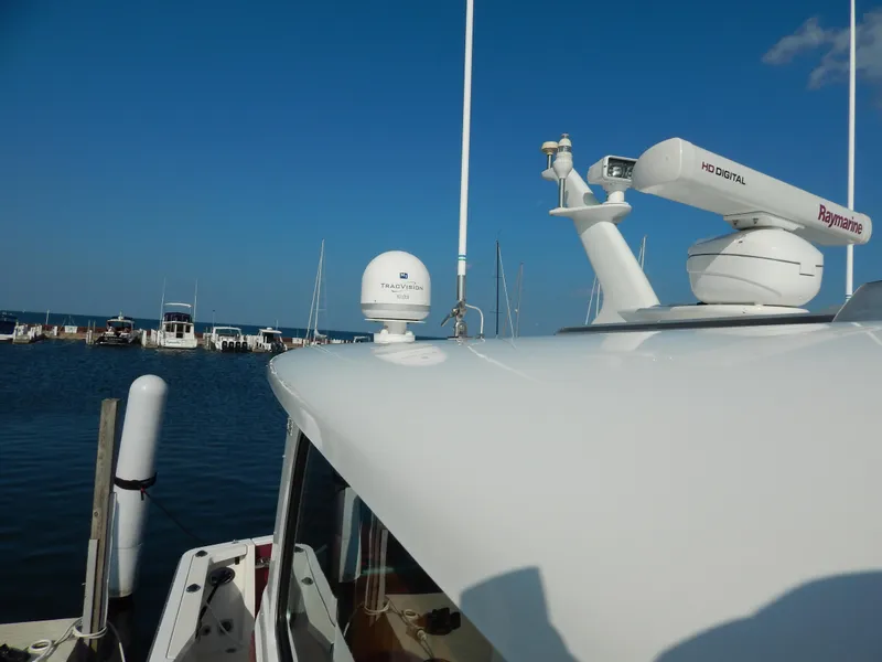 Slide: The Image of 2010 Sabre 40 Sedan yacht with radar and satellite equipment, docked at a marina. - 6