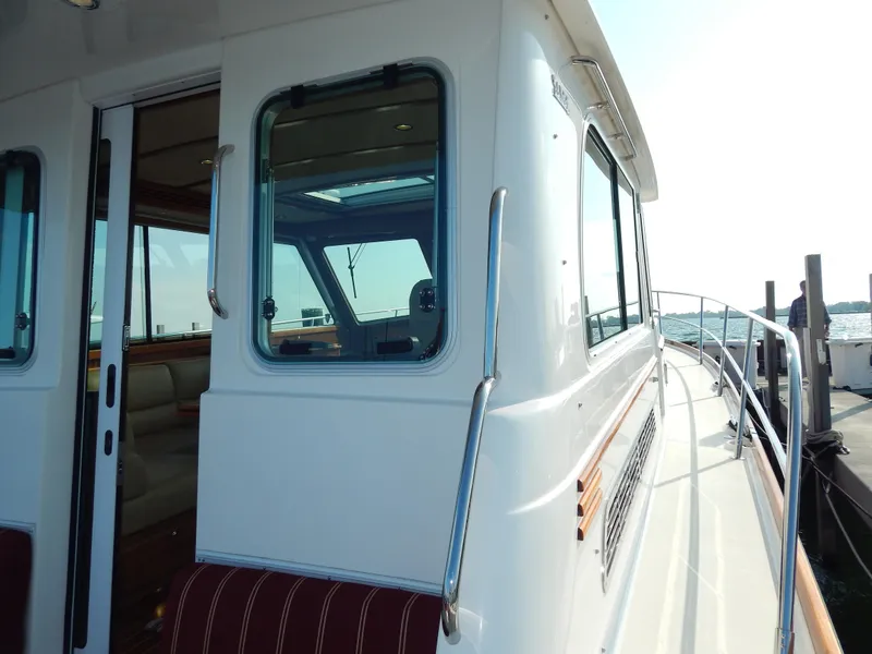 Slide: The Image of 2010 Sabre 40 Sedan yacht exterior with windows and railing, docked by the water. - 7