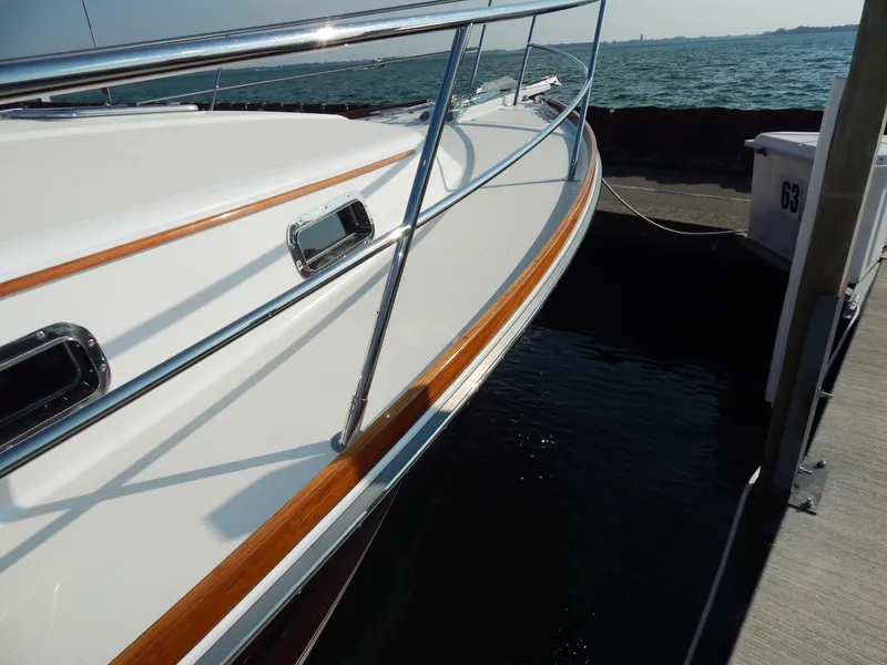 Slide: The Image of 2010 Sabre 40 Sedan yacht docked, showcasing sleek design and polished railings. - 8