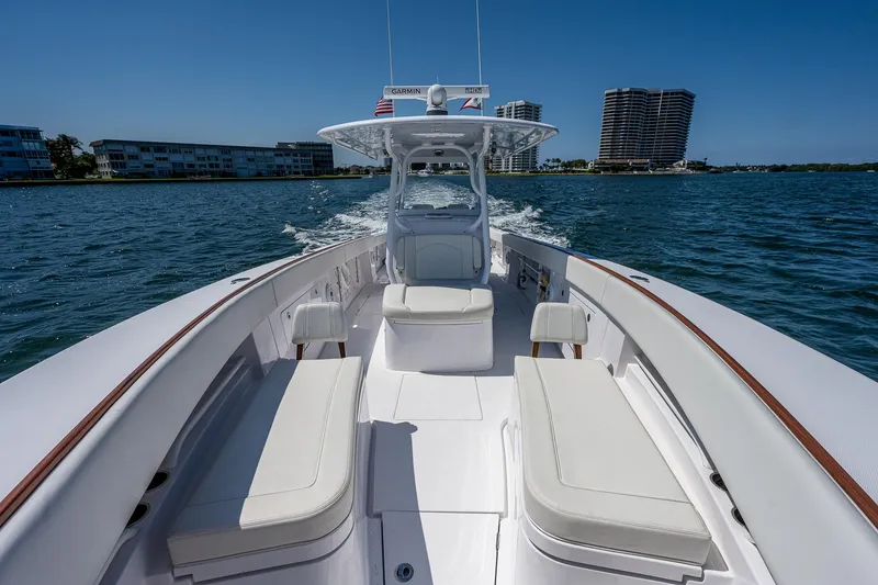 Slide: The Image of 2023 Jupiter 38 boat cruising on water with city skyline in background. - 13