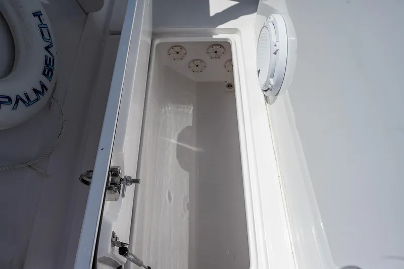 Slide: The Image of Open storage compartment on 2023 Jupiter 38 boat, featuring a white interior and secure latch. - 18