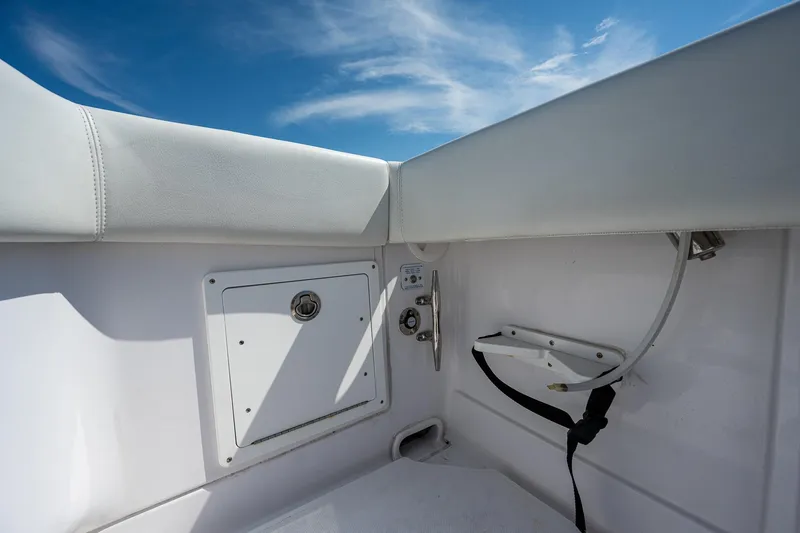 Slide: The Image of Interior view of 2023 Jupiter 38 boat, featuring white upholstery and storage compartment. - 31