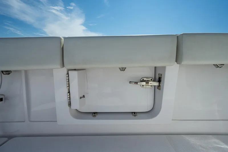 Slide: The Image of 2023 Jupiter 38 boat storage compartment with cushioned seating under a clear blue sky. - 32