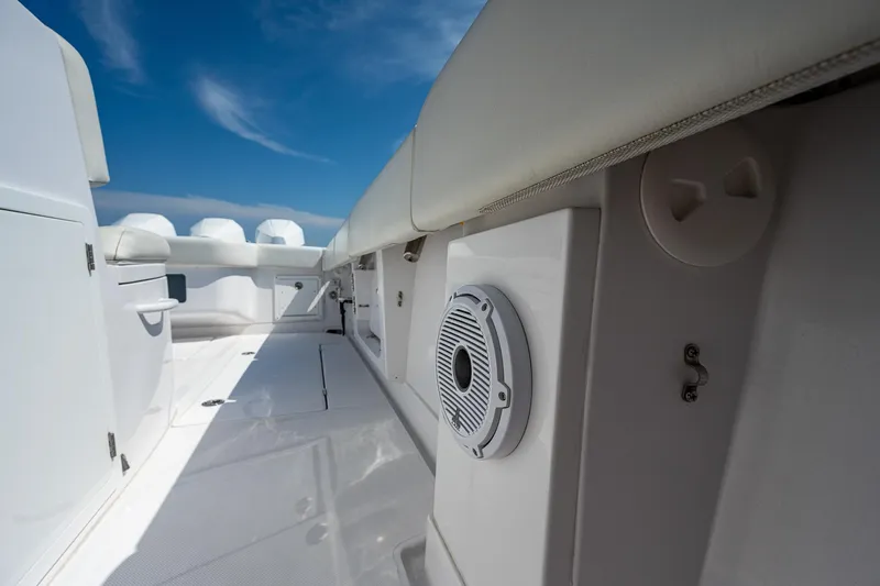 Slide: The Image of 2023 Jupiter 38 boat interior with speaker, white seating, and blue sky background. - 33