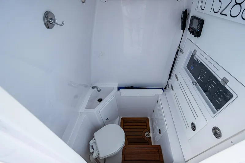 Slide: The Image of 2023 Jupiter 38 boat interior with toilet, sink, and control panel. - 37