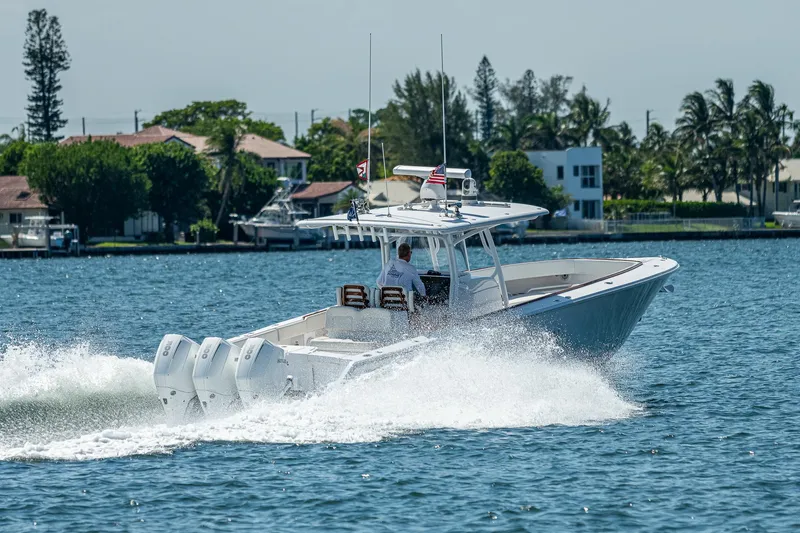 Slide: The Image of 2023 Jupiter 38 boat cruising on a sunny day near waterfront homes. - 4