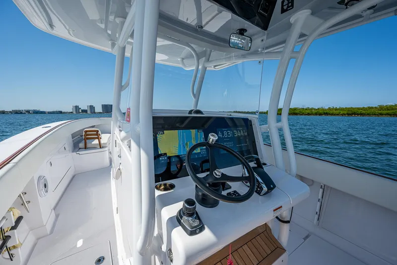 Slide: The Image of 2023 Jupiter 38 boat helm with modern controls, navigating on calm waters. - 40