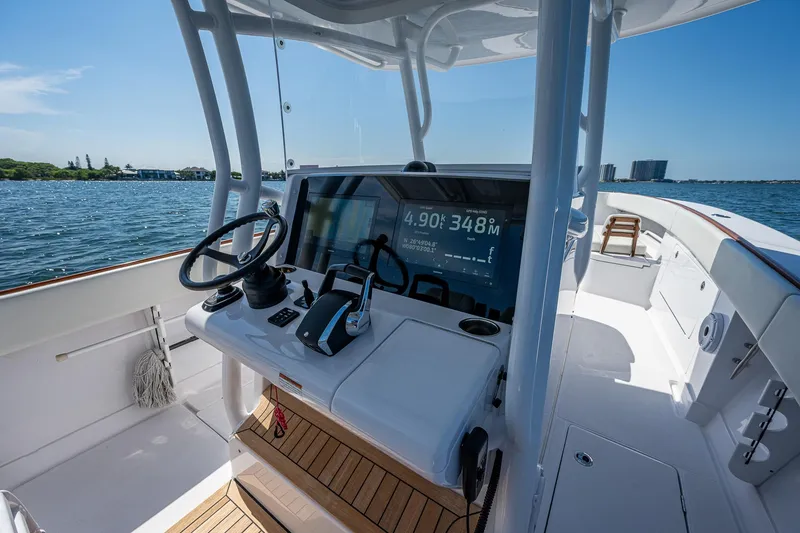 Slide: The Image of 2023 Jupiter 38 boat cockpit with steering wheel and navigation display on open water. - 43
