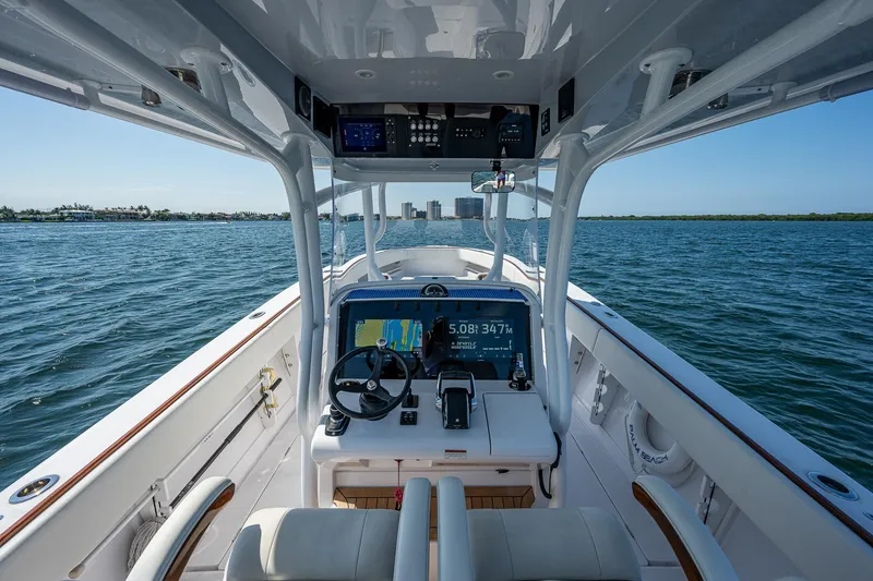Slide: The Image of 2023 Jupiter 38 boat interior with navigation system, steering wheel, and ocean view. - 46
