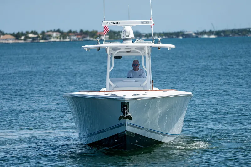 Slide: The Image of 2023 Jupiter 38 boat cruising on open water with a person at the helm. - 47