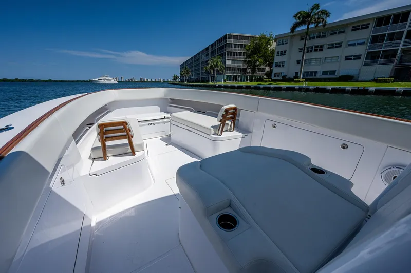 Slide: The Image of 2023 Jupiter 38 boat interior with seating, dockside view, and clear blue sky. - 6