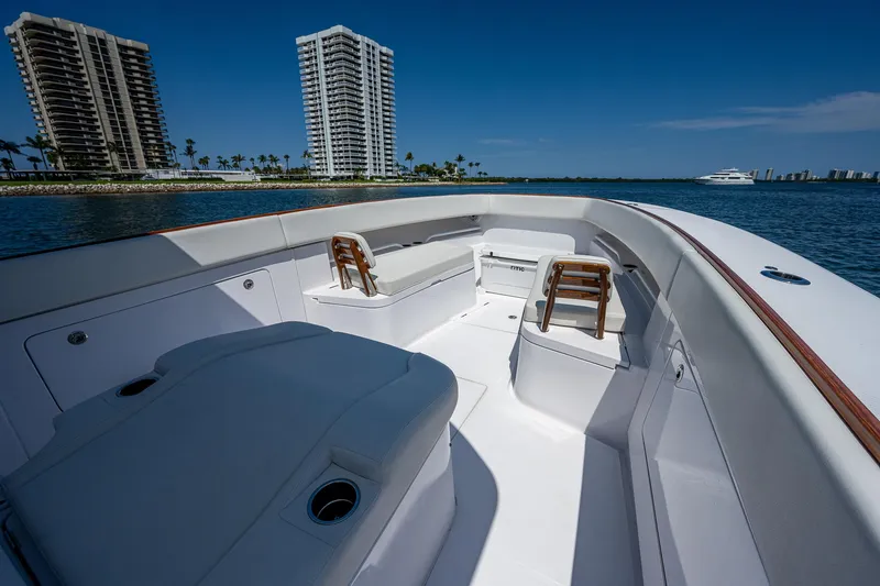 Slide: The Image of Luxurious 2023 Jupiter 38 boat interior with seating, ocean view, and high-rise buildings in the background. - 7