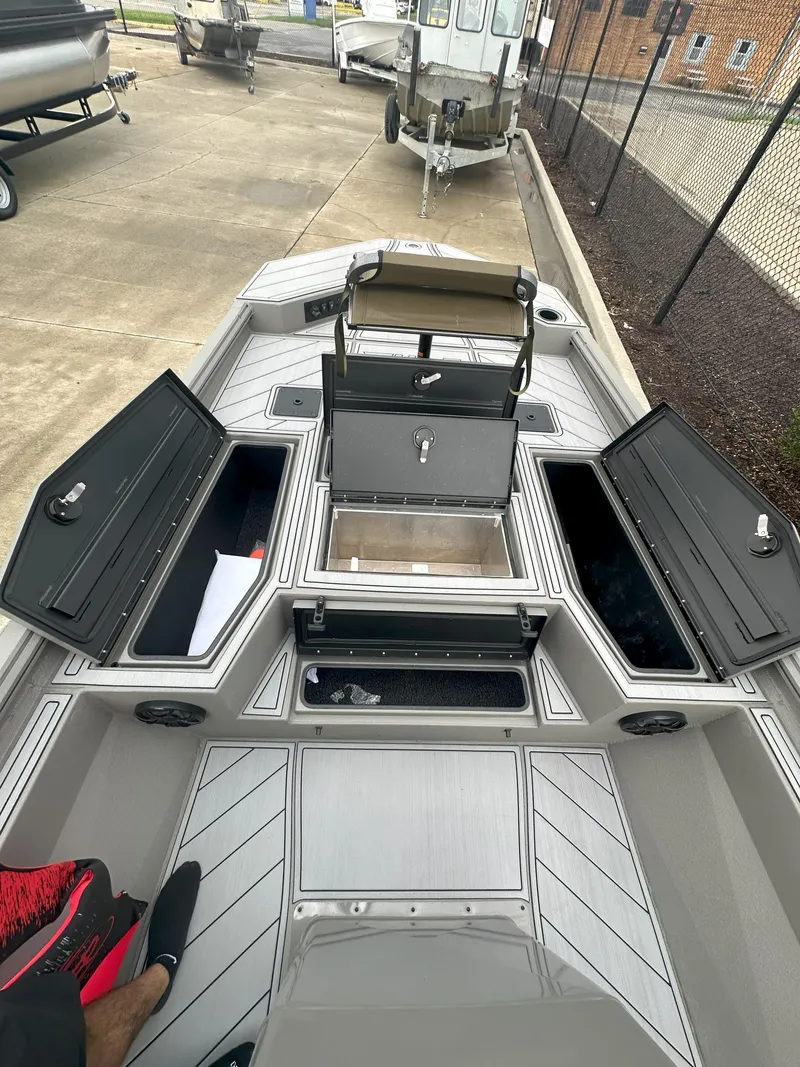 Slide: The Image of 2024 Thor 1900 Center Console boat with open storage compartments on a concrete lot. - 12