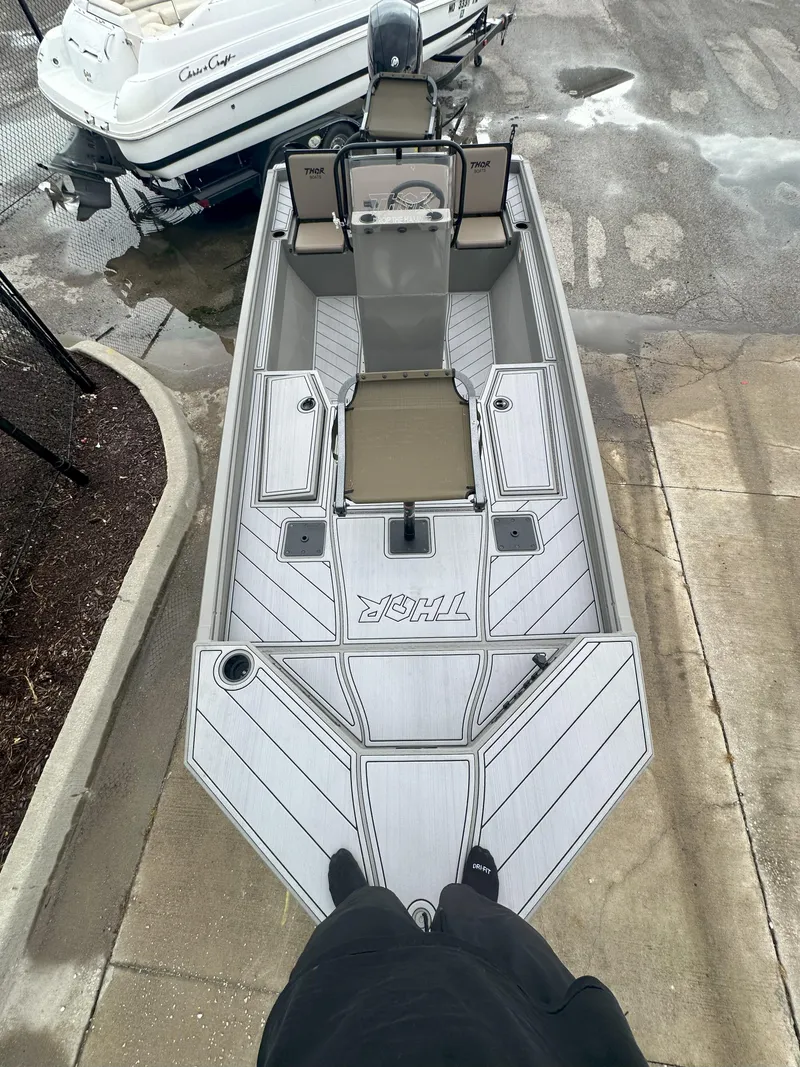 Slide: The Image of 2024 Thor 1900 Center Console boat, top view, docked beside another vessel. - 13