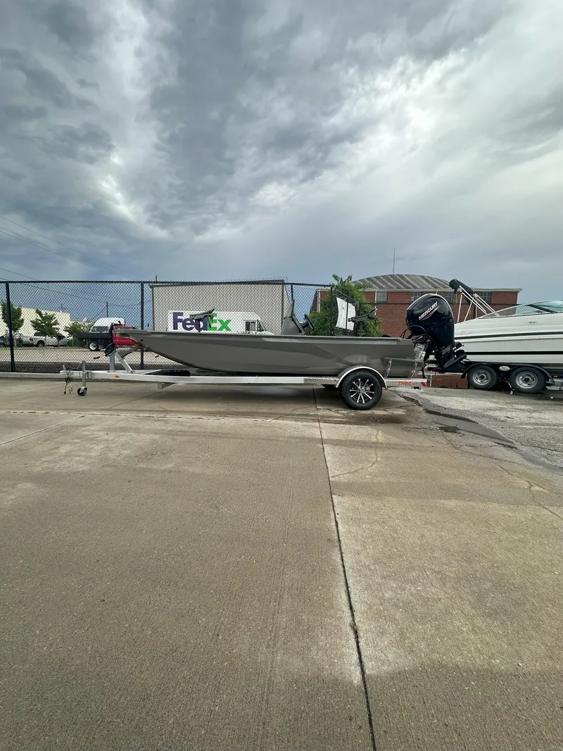 Slide: The Image of 2024 Thor 1900 Center Console boat on trailer, parked near FedEx truck. - 2