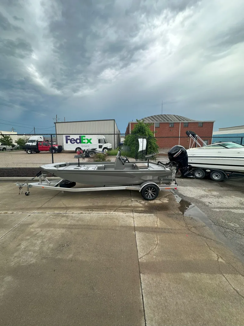 Slide: The Image of 2024 Thor 1900 Center Console boat on trailer, parked near FedEx building under cloudy sky. - 3