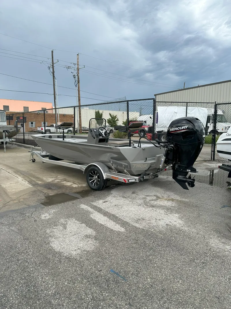 Slide: The Image of 2024 Thor 1900 Center Console boat with Mercury engine on trailer, parked outdoors. - 6
