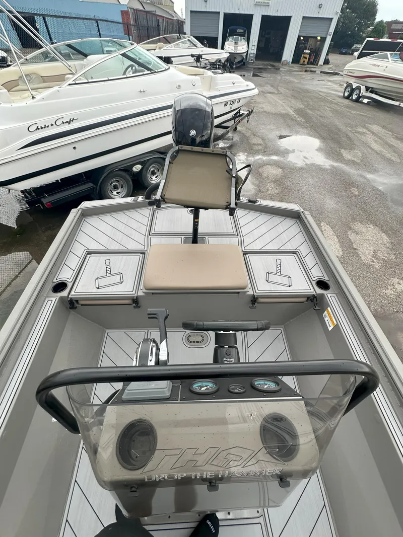 Slide: The Image of 2024 Thor 1900 Center Console boat with modern dashboard and seating, parked in a marina. - 8