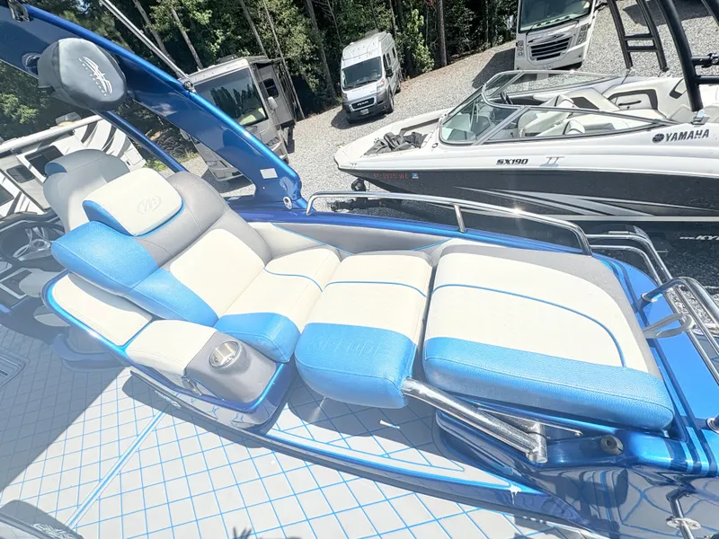 Slide: The Image of 2017 Manitou X-Plode Series 25 XT SRS SHP boat with blue and white seating, parked outdoors. - 17