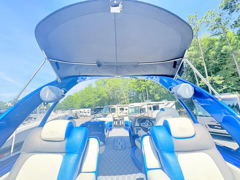 Slide: The Image of 2017 Manitou X-Plode Series 25 XT SRS SHP pontoon boat interior with blue seating and canopy. - 22