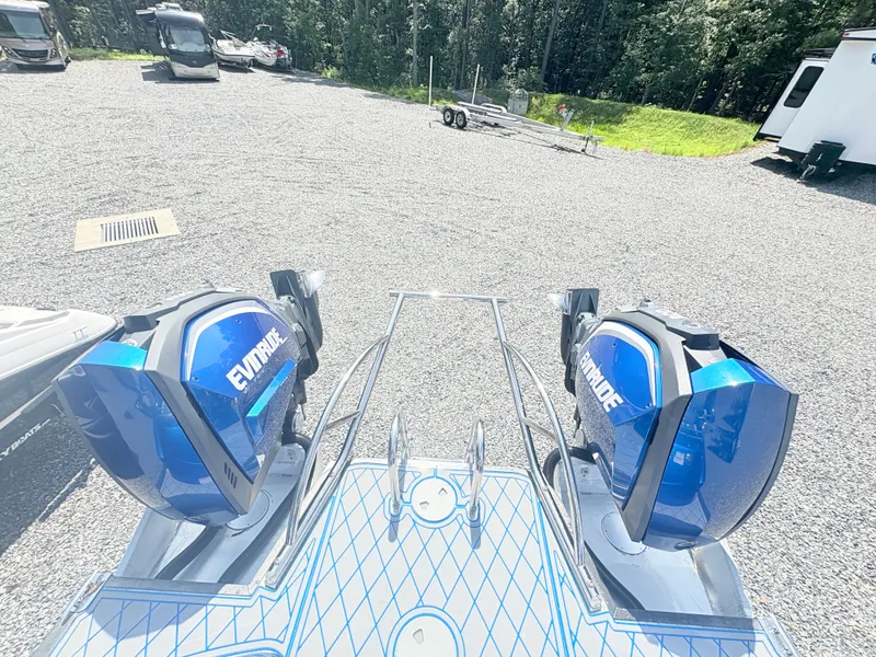 Slide: The Image of 2017 Manitou X-Plode Series 25 XT SRS SHP with dual Evinrude engines in a parking area. - 23