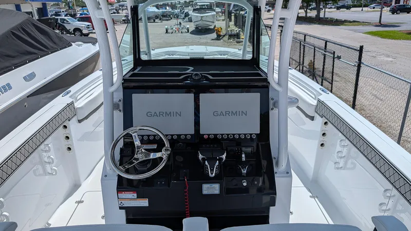 Slide: The Image of 2026 Wellcraft 302 Fisherman boat cockpit with dual Garmin displays and steering wheel. - 11