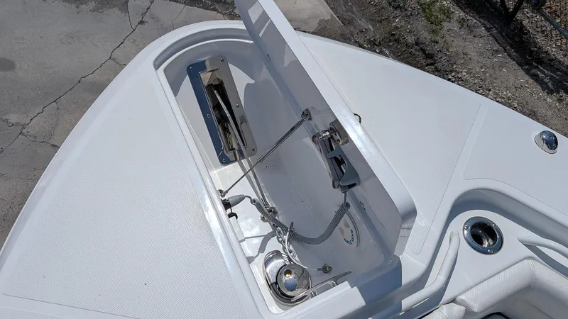 Slide: The Image of 2026 Wellcraft 302 Fisherman boat anchor compartment with open hatch, showcasing storage and hardware. - 16