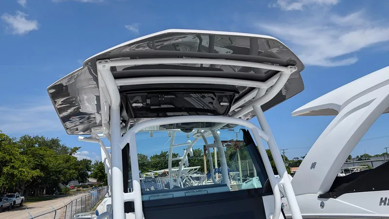 Slide: The Image of 2026 Wellcraft 302 Fisherman boat with sleek T-top design under clear blue sky. - 18