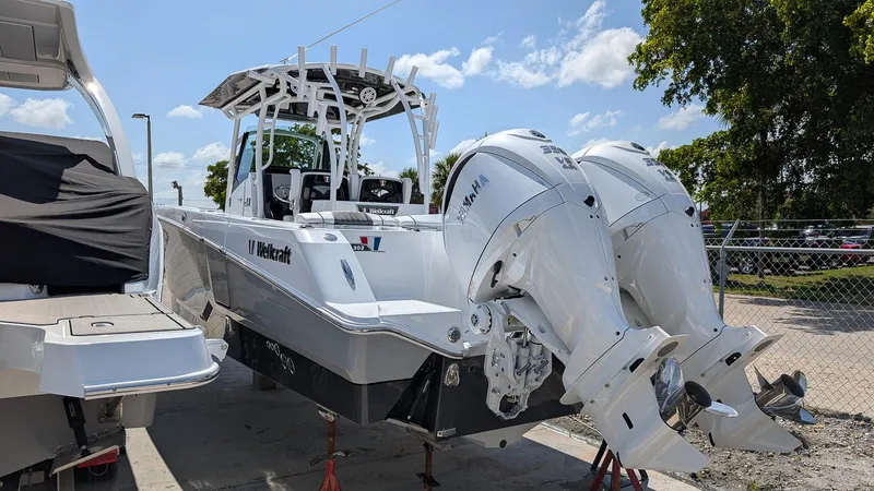 Slide: The Image of 2026 Wellcraft 302 Fisherman boat with dual Yamaha engines, parked outdoors. - 2