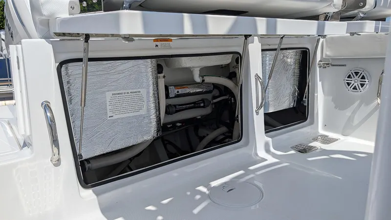 Slide: The Image of 2026 Wellcraft 302 Fisherman boat storage compartments with open hatches and visible equipment. - 6