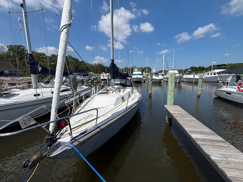 Slide: The Image of 1988 Bristol 33.3 sailboat docked at a marina under a clear blue sky. - 1