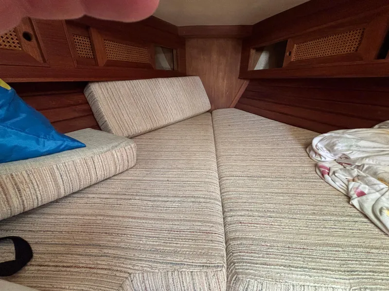 Slide: The Image of Interior cabin of a 1988 Bristol 33.3 sailboat with striped cushions and wooden paneling. - 23