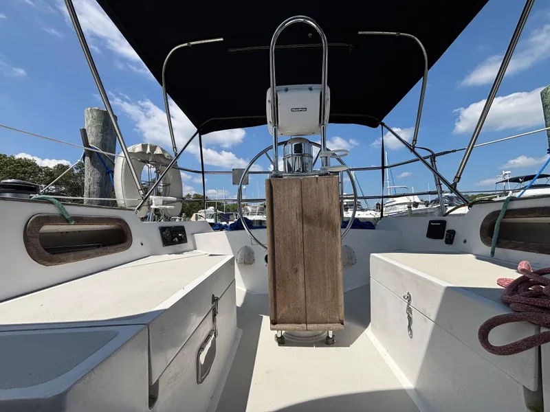 Slide: The Image of Cockpit of 1988 Bristol 33.3 sailboat with steering wheel and canopy under blue sky. - 29