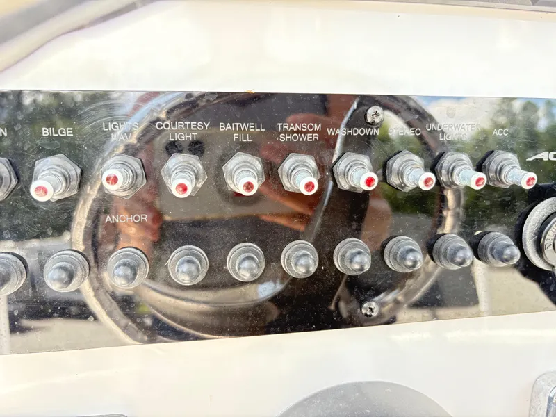 Slide: The Image of Control panel of 2022 Aquasport 2300 CC boat with labeled switches. - 12