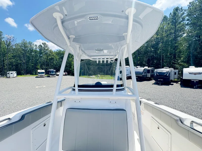 Slide: The Image of 2022 Aquasport 2300 CC boat with T-top, parked in a lot with RVs. - 21