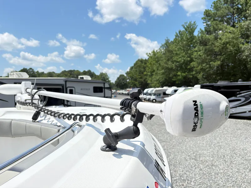 Slide: The Image of 2022 Aquasport 2300 CC boat with Rhodan GPS anchor, parked outdoors under a blue sky. - 24