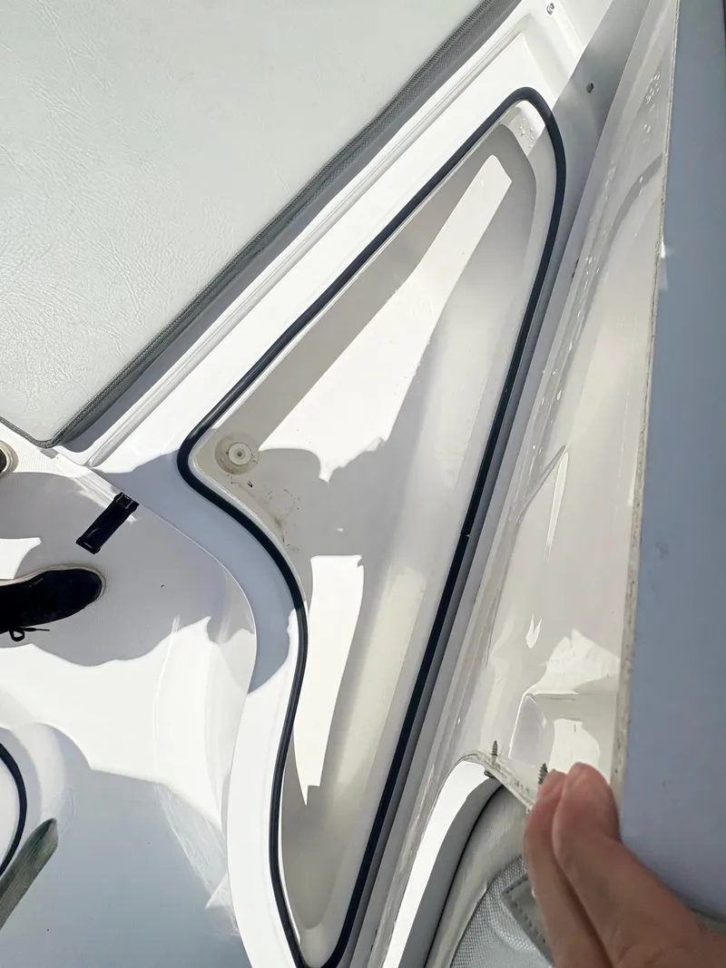 Slide: The Image of 2022 Aquasport 2300 CC boat storage compartment with open hatch and visible gasket. - 26
