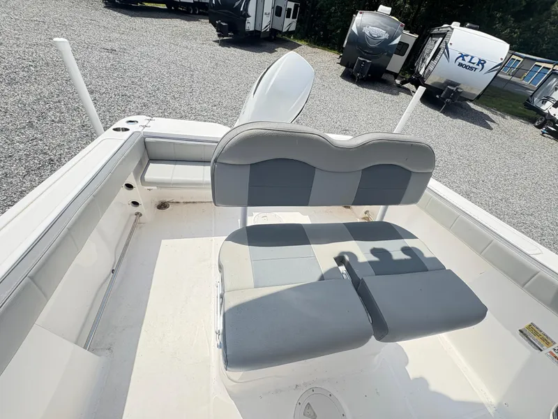 Slide: The Image of 2022 Aquasport 2300 CC boat interior with gray seating, parked near RVs. - 36
