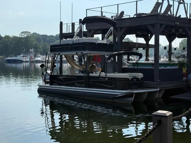 Slide: The Image of 2022 Premier 250 Sunsation pontoon boat docked at a marina. - 0