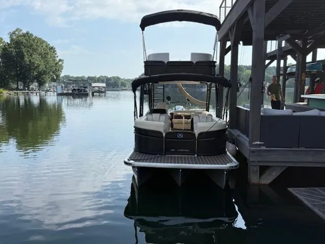 Slide: The Image of 2022 Premier 250 Sunsation pontoon boat docked on a calm lake. - 1