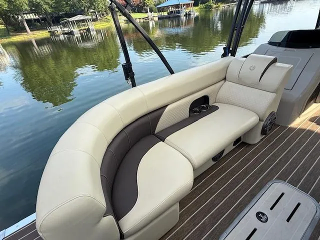 Slide: The Image of 2022 Premier 250 Sunsation boat with elegant seating, overlooking a serene lake. - 11