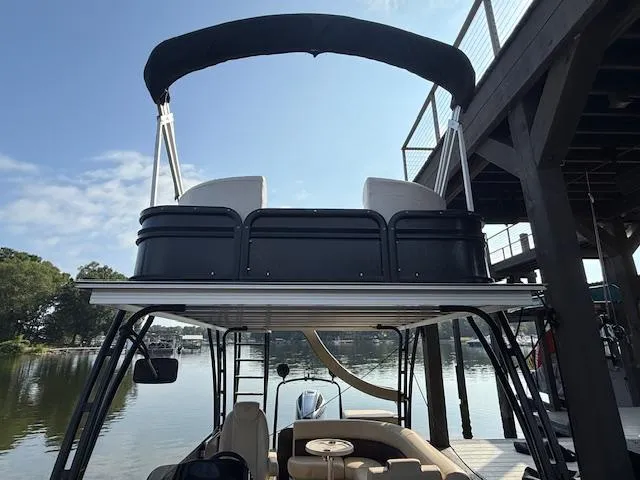 Slide: The Image of 2022 Premier 250 Sunsation pontoon boat with upper deck and canopy, docked by a wooden pier. - 14