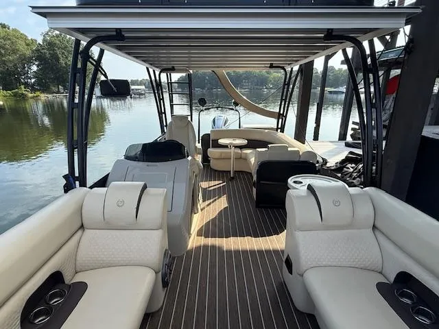 Slide: The Image of 2022 Premier 250 Sunsation pontoon boat with luxurious seating and sleek design on a serene lake. - 15