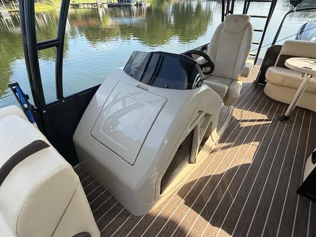 Slide: The Image of 2022 Premier 250 Sunsation boat interior with helm, seating, and water view. - 16