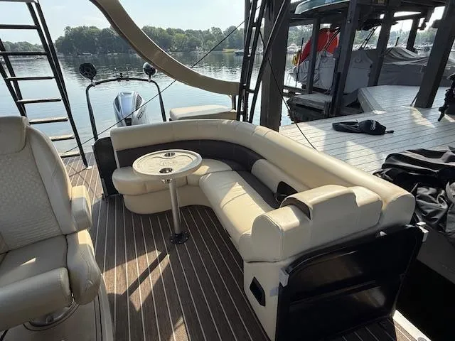Slide: The Image of Luxurious seating area on 2022 Premier 250 Sunsation pontoon boat, docked by a serene lake. - 19