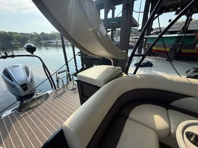 Slide: The Image of 2022 Premier 250 Sunsation boat interior with seating and outboard motor at dock. - 22