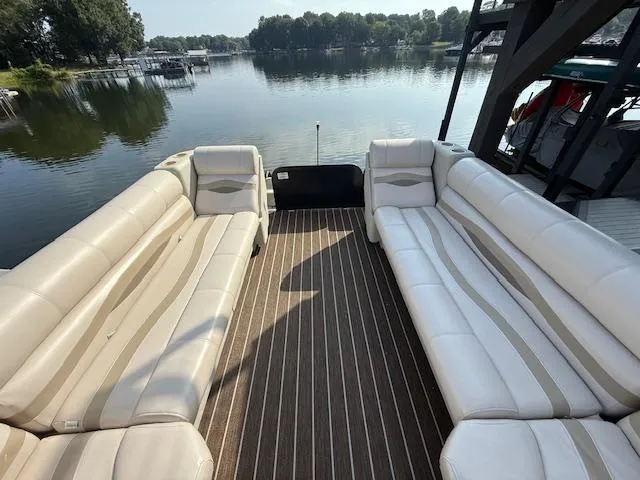 Slide: The Image of 2022 Premier 250 Sunsation pontoon boat with spacious seating on a serene lake. - 27