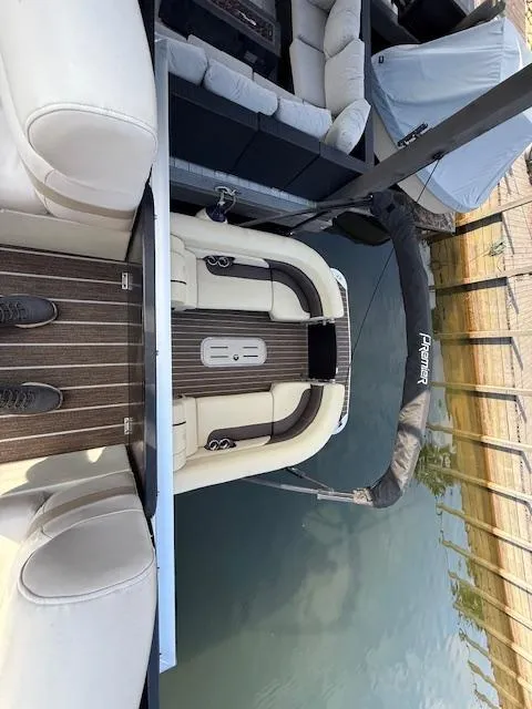 Slide: The Image of 2022 Premier 250 Sunsation boat with cushioned seating, docked on calm water. - 28