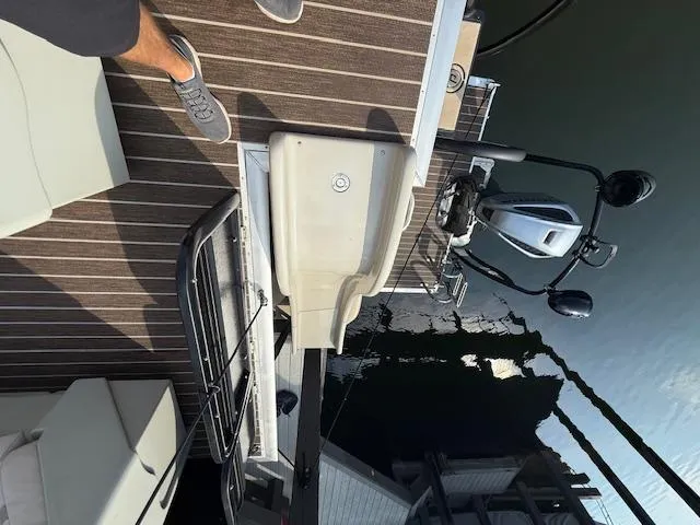 Slide: The Image of 2022 Premier 250 Sunsation boat deck with motor and seating, docked on calm water. - 30